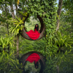 Abigail Edem Hunu seated inside a circular woven structure, symbolising holding space, safety and healing for survivors of abuse